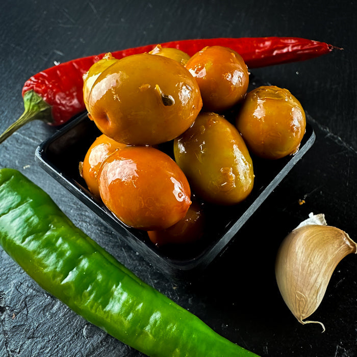 Zaļās olīvas ar eļļu, sarkaniem un zaļajiem pipariem