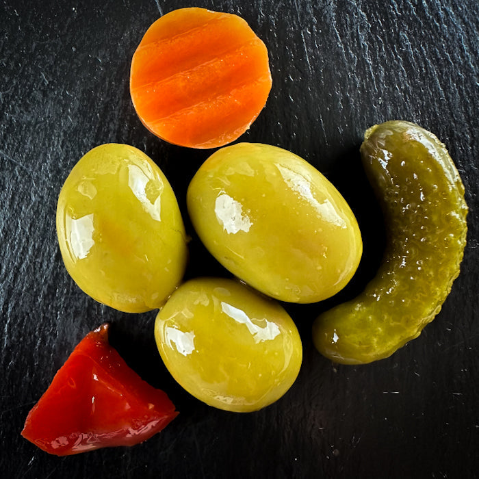 Olīvas zaļās ar kauliņiem dārziņu marinādē un dārziņiem